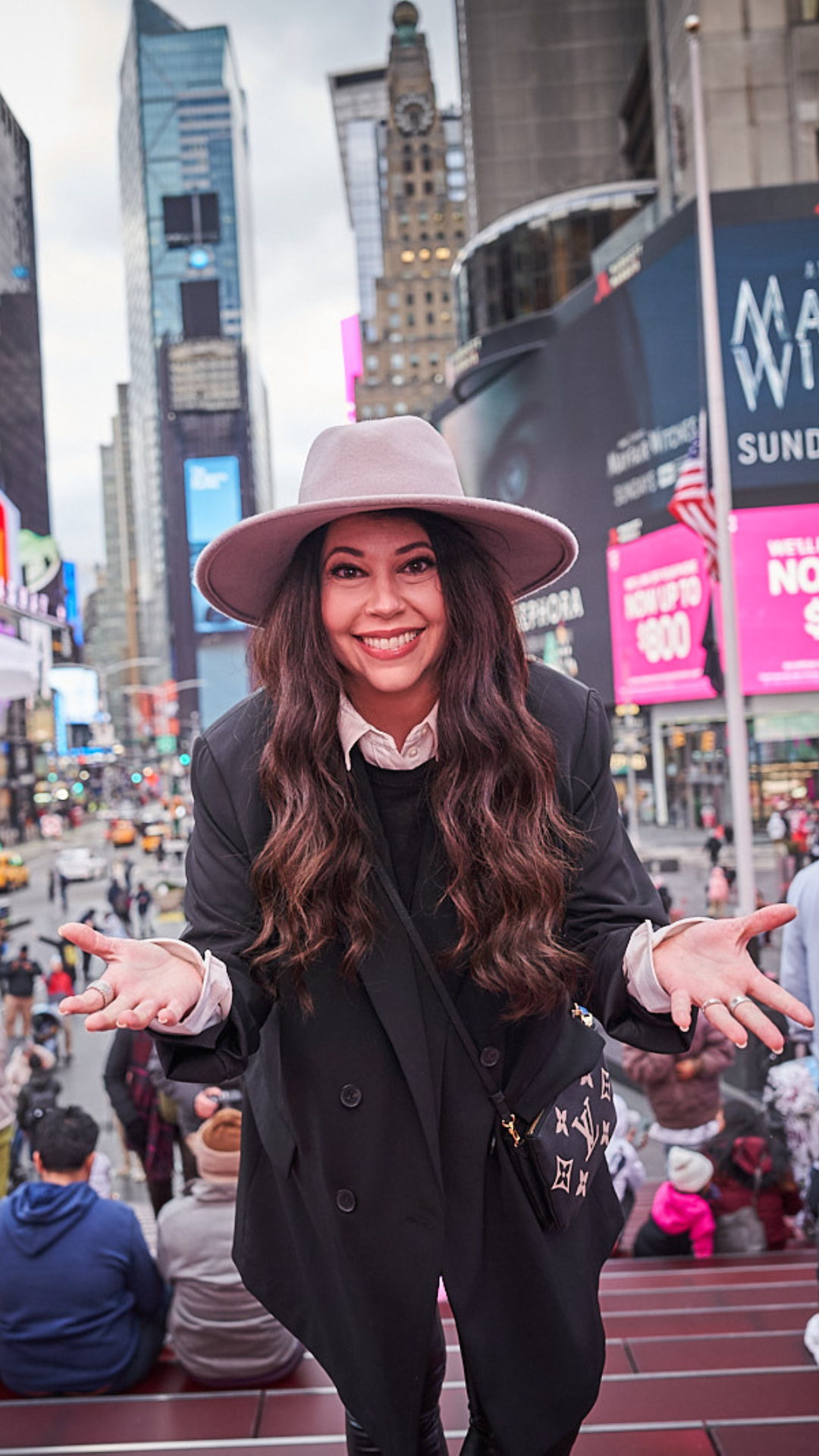 Leslie, founder of Erapreneur, smiling with open arms in Times Square
